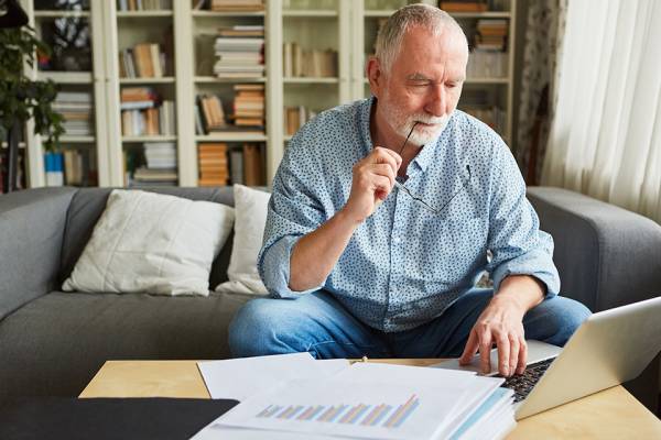 Foto: Älterer Mann füllt Unterlagen aus