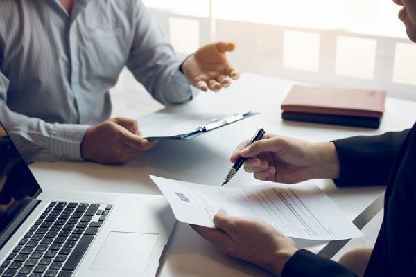 Foto: Personen besprechen Akten