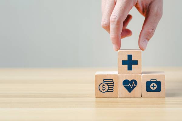 Foto: Hand legt einen Holzblock auf andere Blöcke